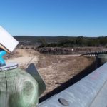 Little Guys Movers' mascot in front of a long road for San Marcos long distance moving