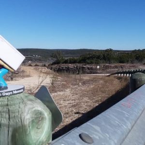 Little Guys Movers' mascot in front of a long road for San Marcos long distance moving