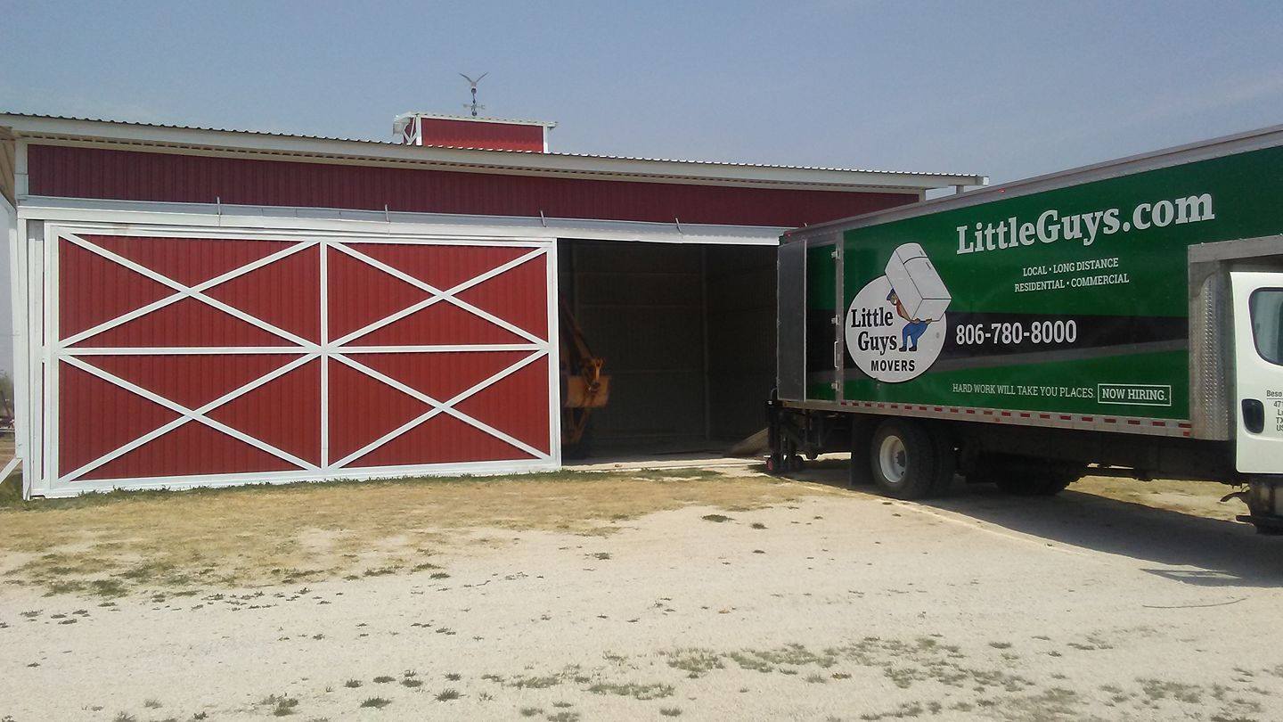 lubbock movers moving truck in front of red barn