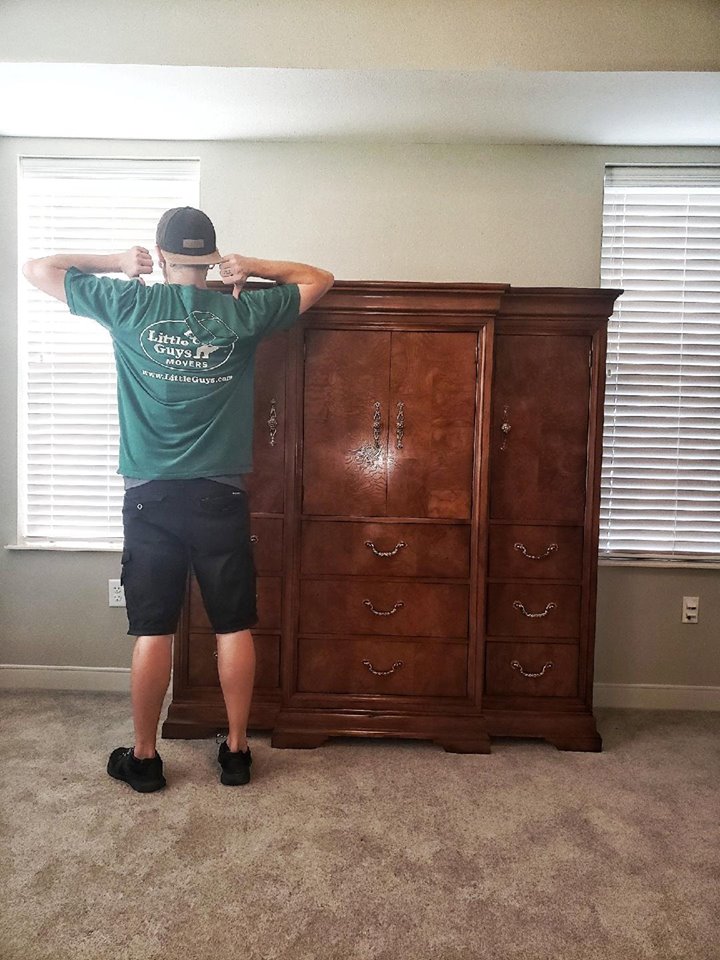 College Station movers with armoire in Little Guys shirt