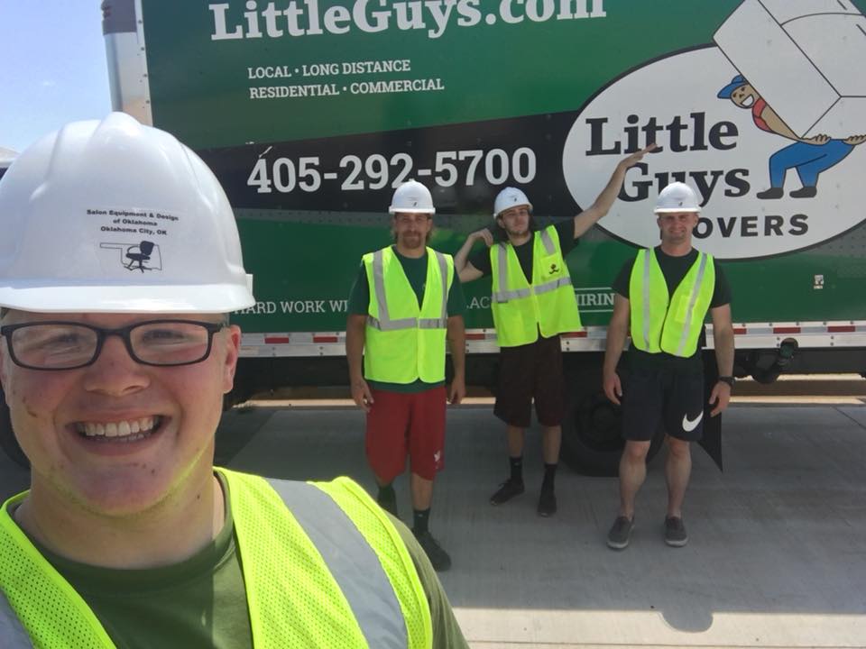 norman moving truck with movers in safety gear in front