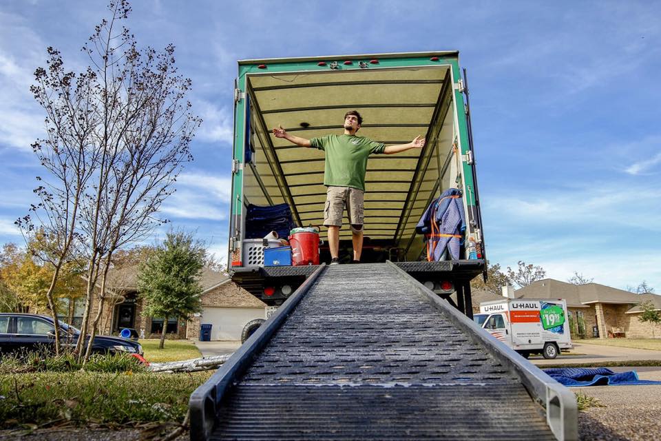 greensboro careers mover standing in moving truck with arms wide