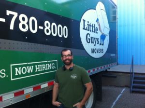 Little Guys Movers Gainesville new Branch Manager, Rusten Bullard in front of a Little Guys Movers moving truck.
