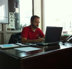 One of Little Guys Movers' leadership team at work on his laptop in the Lexington office